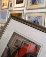 Ingelijst werk met passe-partout tegen de wand van de winkel